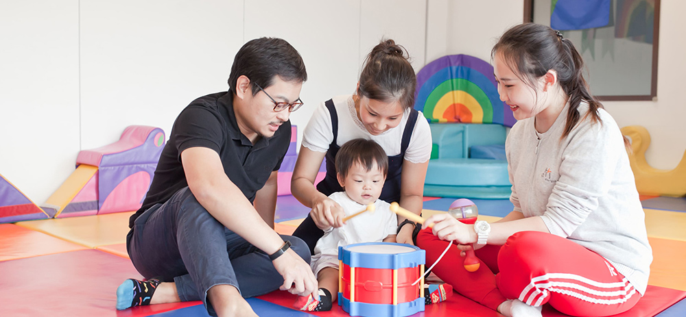 A-family-engaging-in-play-with-a-child-in-a-vibrant-playroom-surrounded-by-toys-and-a-warm-inviting-atmosphere---Chengzhu-Mandarin-Centre