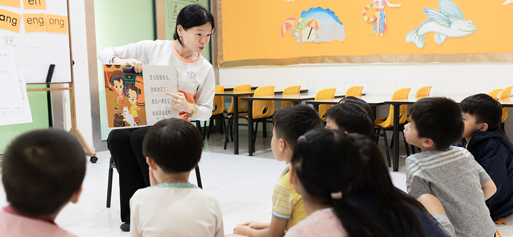 A-teacher-reading-to-a-group-of-students-in-a-classroom-engaging-them-in-learning-Mandarin-language-through-interactive-storytelling---Chengzhu-Mandarin-Centre